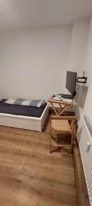 een slaapkamer met een bed en een bureau met een laptop bij Goldfisch-1-Person in Brunsbüttel