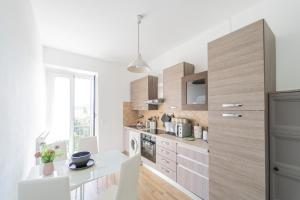 a kitchen with white walls and wooden cabinets at 238 - Casa Al Mà, Vista MARE, Pace e Natura - PARCHEGGIO GRATIS INCLUSO in Sestri Levante