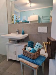 a bathroom with a basket of towels and a sink at Ferienwohnung Rose - b47219 in Peißenberg
