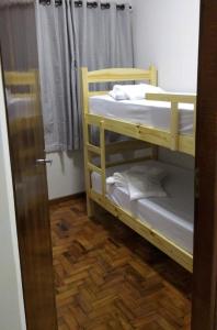 Zimmer mit 2 Etagenbetten neben einer Tür in der Unterkunft Confortável e espaçosa in Bebedouro