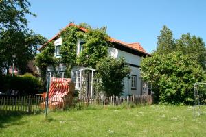 una casa con una silla delante en "Weißes Haus" 9123II - Fehmarn, en Fehmarn