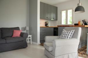 uma sala de estar com um sofá e cadeiras e uma cozinha em "Weißes Haus" 9123II - Fehmarn em Fehmarn