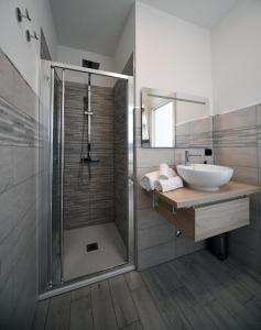 y baño con ducha acristalada y lavamanos. en B&B La casa di Graz, en Reggio Emilia