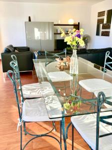 a glass table with a vase of flowers on it at City Break Picquecailloux in Bordeaux