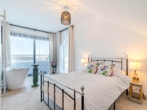 a bedroom with a bed and a tub and a window at The Bungalow in Rushton Spencer