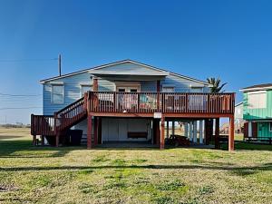 a house with a large deck on the front of it at Flip Flop Beachside in Galveston