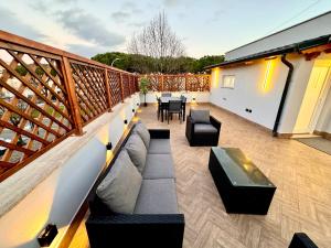 a patio with a couch and chairs on a balcony at Luxury Apartment Togliatti in Rome
