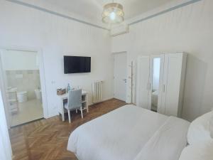 a white bedroom with a bed and a desk at AZZURRA Ridi Che Ti Passa in Alassio