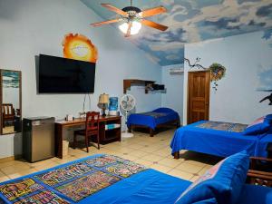 Habitación con 2 camas, escritorio y TV. en Las Lajas Beach Resort, en Las Lajas