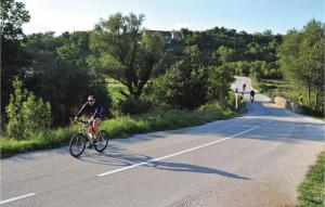 a man riding a bike down a road at Cozy Home In Neoric With House A Panoramic View in Neorić