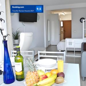 einen Tisch mit einer Flasche Wein und Obst darauf in der Unterkunft Edificio Seguro de Sol, Puerto La Cruz, Islas Canarias Tenerife in Puerto de la Cruz