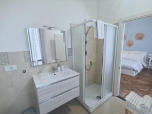 a white bathroom with a shower and a sink at AZZURRA Ridi Che Ti Passa in Alassio