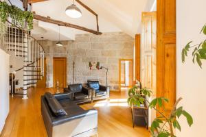een woonkamer met lederen meubels en een stenen muur bij Casa Trindade Apartments in Porto