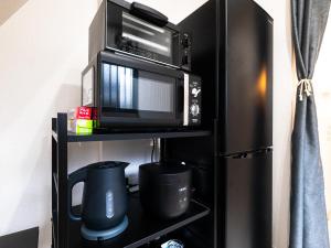 a microwave and a toaster oven on a shelf at 一棟貸しの民泊いとんちゅ in Nagasaki