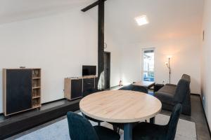 Apartmány Modřany في براغ: غرفة معيشة مع طاولة وكراسي خشبية