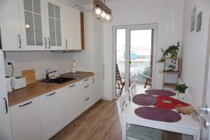uma cozinha com armários brancos e uma mesa branca com um lavatório em Rosi Residence em Chişoda