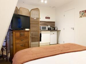 a bedroom with a bed and a tv and a kitchen at Monet - appartement pour 2 personnes in Chartres