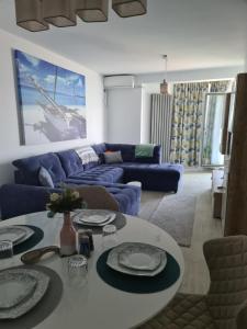 sala de estar con sofá azul y mesa en ALZ Beach Apartments in Alezzi Beach Resort, en Mamaia Nord – Năvodari