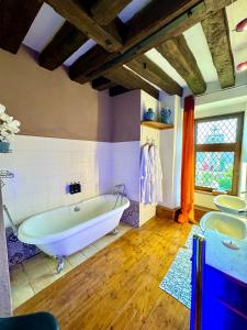 een grote badkamer met een bad en 2 wastafels bij MEUBLE PANORAMIQUE 2 à 6 PERSONNES AU CHÂTEAU DE JALLANGES in Vernou-sur-Brenne