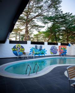 a swimming pool with chairs and a wall with graffiti at Portland Suites in Abuja