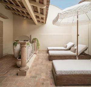 a room with three beds and an umbrella at Casa Alondra in Morelia