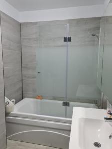 uma casa de banho com uma banheira branca e um lavatório. em ALZ Beach Apartments in Alezzi Beach Resort em Mamaia Nord – Năvodari