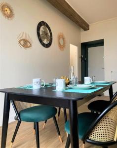 a dining room table with chairs and a clock on the wall at Le Gatsby in Chartres