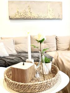 a coffee table with a candle and a wicker coffee table with a living room at Modern Charming Studio Narva Center in Narva