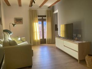 - un salon avec un canapé et une télévision dans l'établissement Casa Román, à Albarracín