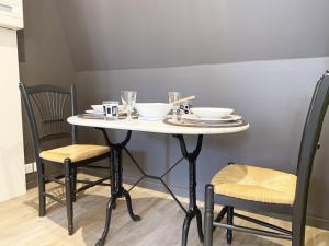 un tavolo bianco con sedie, piatti e bicchieri di Klimt - Parking - Independent Entrance a Chartres