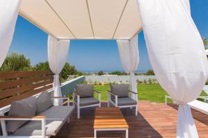 a gazebo with two chairs and a table at Vilana Exclusive Villas in Skouloúfia