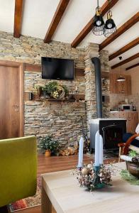 sala de estar con pared de piedra y chimenea en Restuarant-Apartments T'ga za jug Lazaropole, en Lazaropole