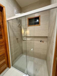 a shower with a glass door in a bathroom at POUSADA PONTA DA ASA in Coruripe