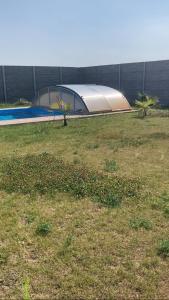 a tent in a field next to a building at Dom s bazénom a záhradou na dovolenku snov in Topoľníky