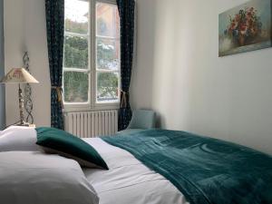 a bedroom with a bed with a green blanket on it at Van Gogh in Chartres +2 photos