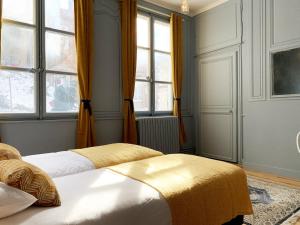 a bedroom with two beds and two windows at Van Gogh in Chartres