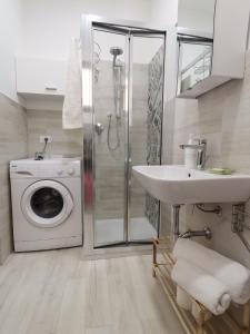 uma casa de banho com uma máquina de lavar roupa e um lavatório em CasAnna em Castellammare del Golfo
