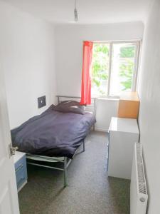 1 dormitorio con cama, ventana y escritorio en Cosy Single Room in Redditch: Free Parking/Wi-fi en Headless Cross