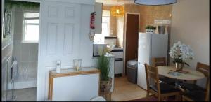 cocina con mesa y nevera blanca en Stunning 2-Bed Chalet in Hemsby Great Yarmouth, en Great Yarmouth