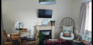 sala de estar con chimenea y TV en la pared en Stunning 2-Bed Chalet in Hemsby Great Yarmouth, en Great Yarmouth