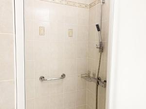 ducha con puerta de cristal y ducha en Le Mainvillois - Parking Included, en Mainvilliers