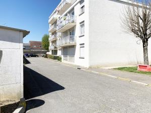 an empty street in front of a white building at Le Mainvillois - Parking Included in Mainvilliers