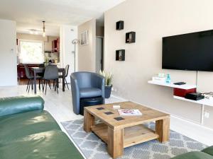 uma sala de estar com um sofá e uma mesa em Le Mainvillois - Parking Included em Mainvilliers
