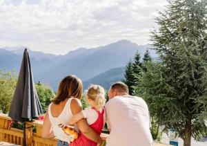 una familia de pie en una terraza con vistas a las montañas en Résidence Routes du Monde ATC Saint-François-Longchamp, en Saint-François-Longchamp