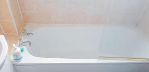 a bathroom with a white tub and a sink at Cosy Single Room in Redditch: Free Parking/Wi-fi in Headless Cross