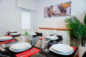 uma sala de jantar com uma mesa com pratos e copos de vinho em Sal Catedral Suite en pleno corazón de León em León