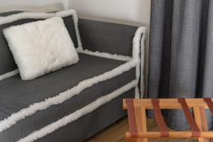 una cama gris con una almohada blanca encima en Bio Hotel Hermitage en Madonna di Campiglio