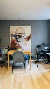 una sala da pranzo con tavolo, sedie e un dipinto di ApartmentInCopenhagen Apartment 1580 a Copenaghen
