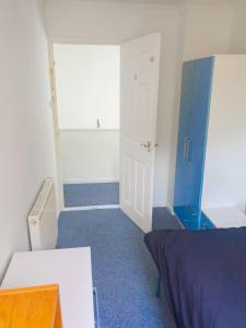 une pièce vide avec un lit et une porte dans l'établissement Cosy Single Room in Redditch: Free Parking/Wi-fi, à Headless Cross