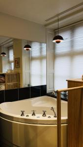 a large bathroom with a tub and a large mirror at ApartmentInCopenhagen Apartment 1580 in Copenhagen